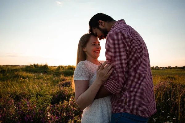 Paar in den Strahlen der untergehenden Sonne umarmen — Stockfoto