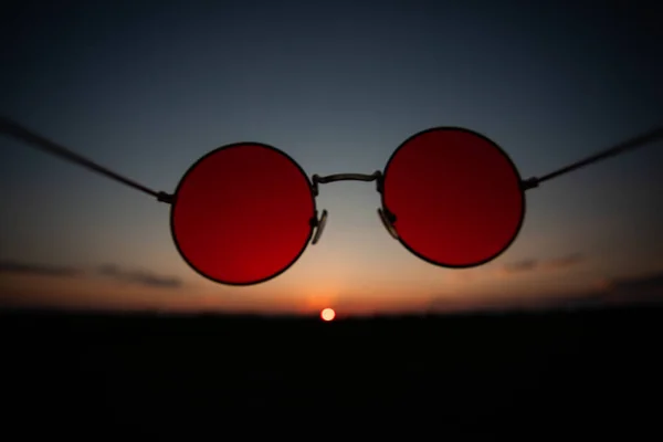 Sommersonnenuntergang durch die Sonnenbrille mit roten Gläsern — Stockfoto