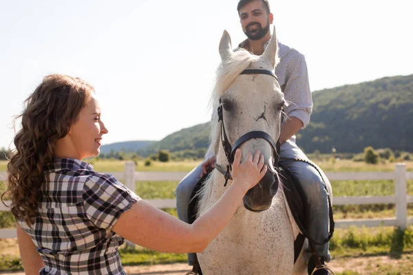 Das junge Paar ruht auf einem Pferdehof — Stockfoto