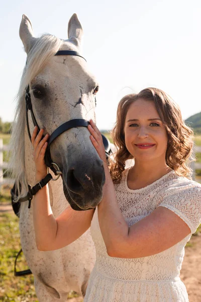 Porträt einer jungen Frau in einem Kleid, das Pferd umarmt — Stockfoto