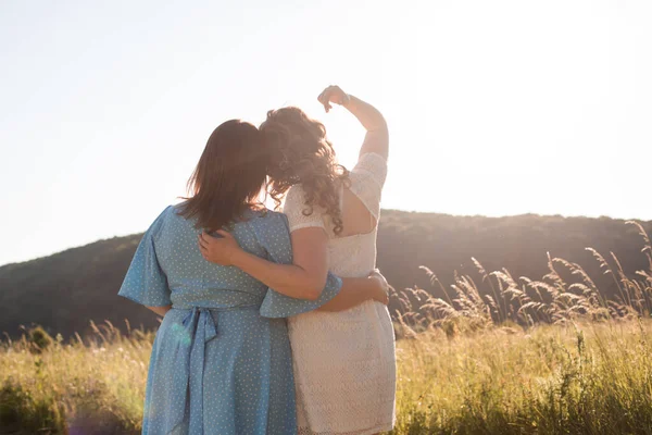 Duas namoradas adultas se abraçam no fundo da natureza — Fotografia de Stock