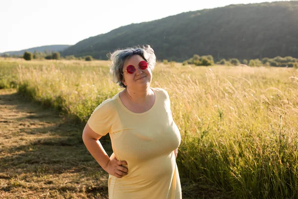 Die fröhliche junge Frau mit Sonnenbrille genießt die Natur — Stockfoto