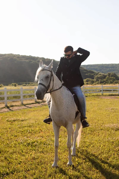 Le jeune homme monte à cheval sur une ferme — Photo