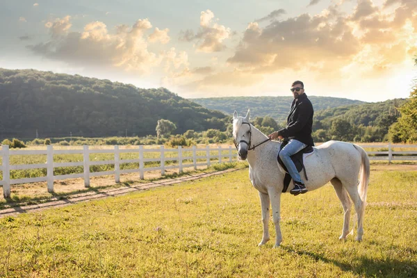 Der junge Mann reitet auf einem Bauernhof — Stockfoto