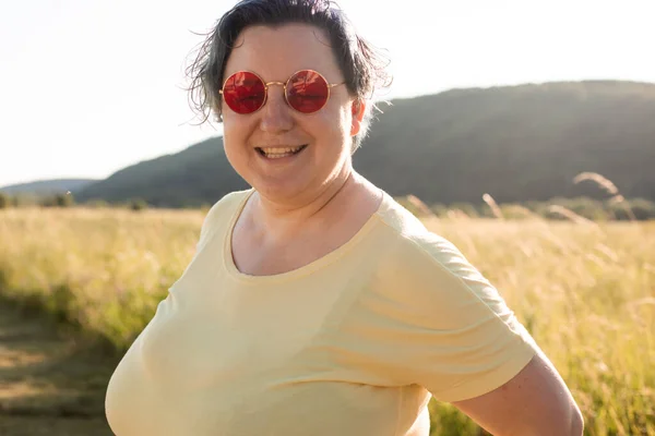 Die fröhliche junge Frau mit Sonnenbrille genießt die Natur — Stockfoto