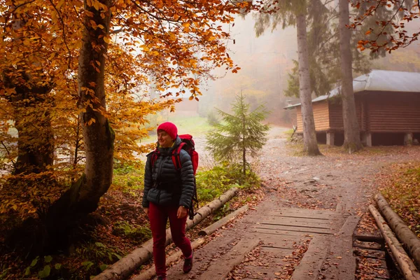 Frau überquert Holzbrücke beim Wandern — Stockfoto