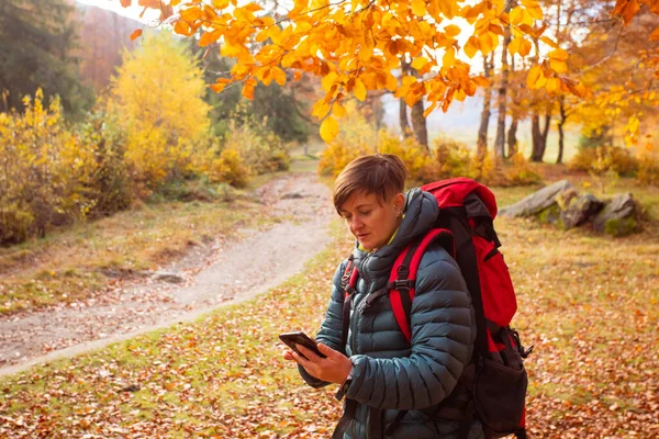 Wanderin nutzt unterwegs Navigation auf dem Smartphone — Stockfoto