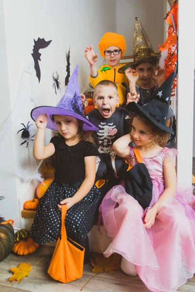 Halloween-Party für Kinder. Kinder in Kostümen auf der Treppe — Stockfoto