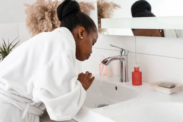Kobieta odświeżająca twarz, myjąca ją w umywalce — Zdjęcie stockowe