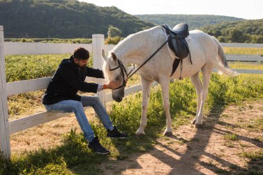 Adam çiftlikte bir atla dinleniyor.