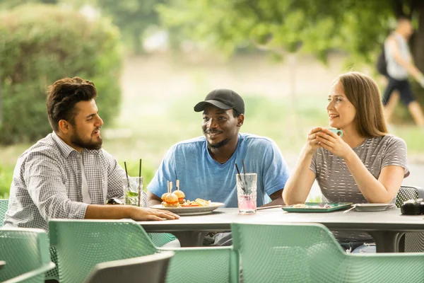 Glada unga vänner som har roligt när de pratar på ett café — Stockfoto