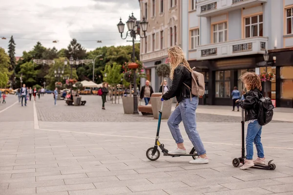 Stylowa młoda mama i córka jeżdżą na skuterach — Zdjęcie stockowe