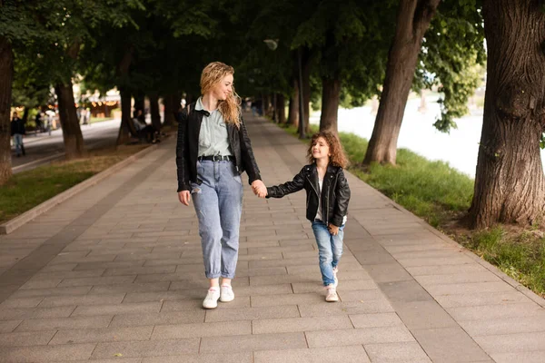 La mamá y la niña caminan juntas a lo largo del paseo marítimo —  Fotos de Stock