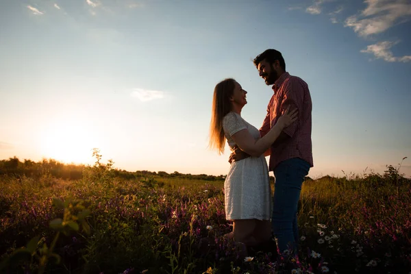 Abraçando casal em raios de pôr do sol — Fotografia de Stock