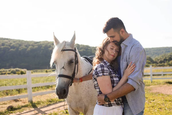 Die glückliche Frau mit ihrem Liebsten steht neben einem Pferd — Stockfoto