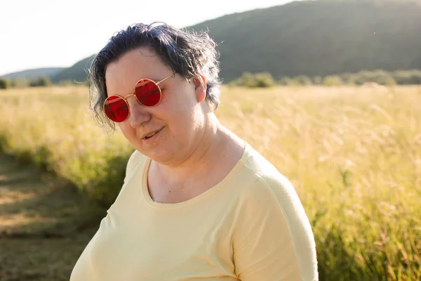 Den glada unga kvinnan i solglasögon njutning natur — Stockfoto