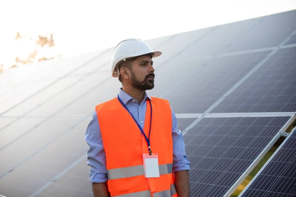 Молодой инженер стоит на солнечной станции — стоковое фото