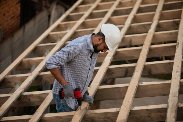 Молодой строитель работает на незавершенной крыше — стоковое фото
