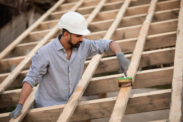 Молодой строитель работает на незавершенной крыше — стоковое фото