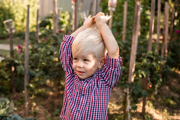 ブロンド髪の男の子とともにキャベツの間に座って — ストック写真