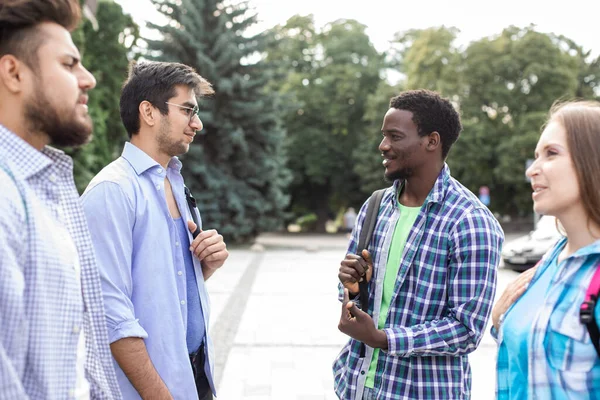 Groupe d'étudiants debout sur le campus et discuter des leçons — Photo