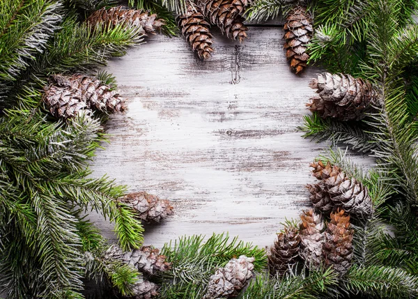 Bílá ošuntělá vánoční hranice se zasněženými borovicemi — Stock fotografie