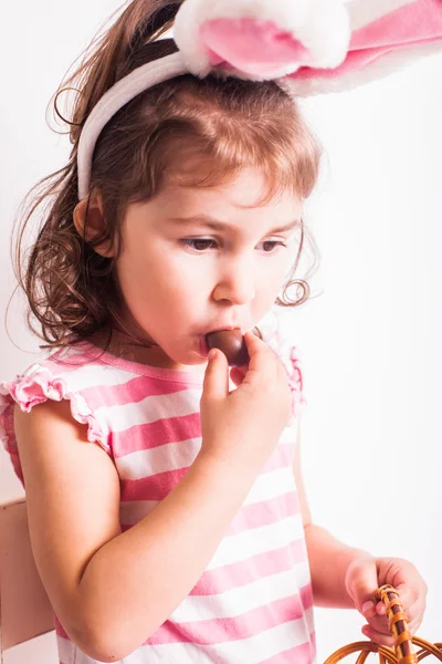 女の子はチョコレートの卵を食べる — ストック写真