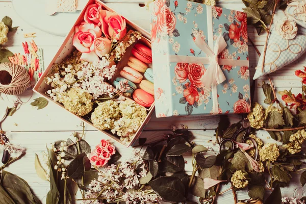Vak met bloemen en bitterkoekjes — Stockfoto