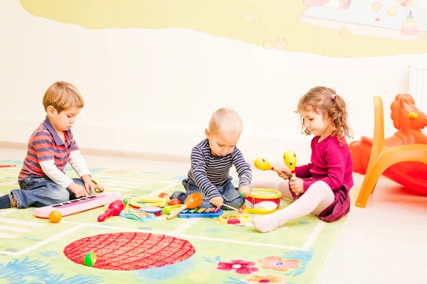 Três crianças brincando com brinquedos — Fotografia de Stock