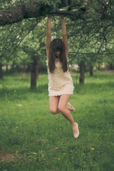 Dívka lpí na větev stromu — Stock fotografie