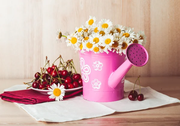 Flower pot and a plate of cherries — Stock Photo, Image