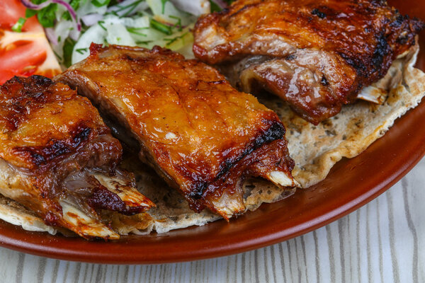 Lamb ribs barbecue with tomato, bread, salad leaves and onion