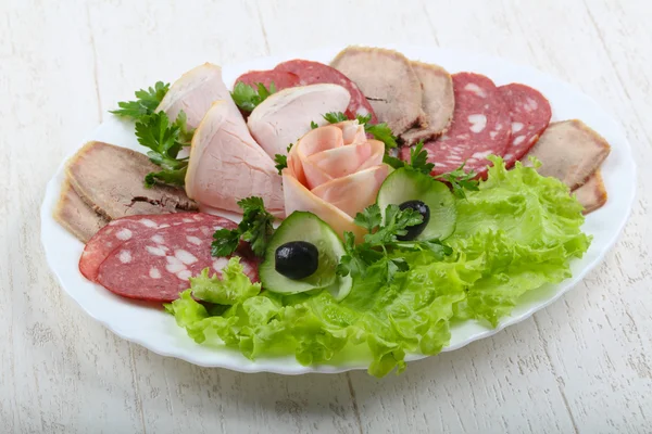 Enchidos e mistura de carne com folhas de salada — Fotografia de Stock