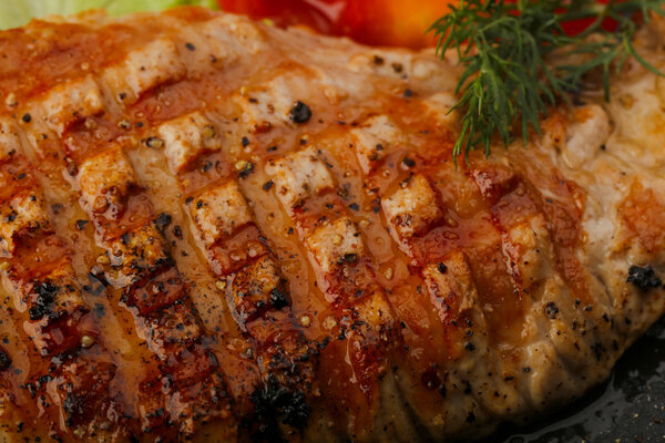 Grilled pork steak with salad leaves and tomato