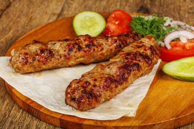 Biftek dilimlenmiş et shashlik sebze servis ediyordu.