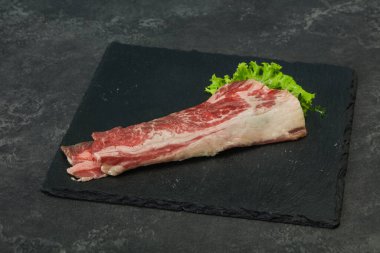 Tahtanın üzerinde çiğ domuz pastırması salata ve kekik servis edildi.