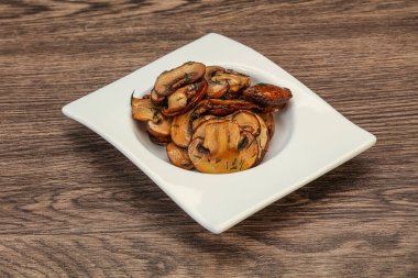 Kavrulmuş şampiyon, kasede otlar ve baharatlar var.