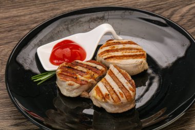 Domates soslu ızgara domuz madalyonu. Biberiye servis ediliyor.