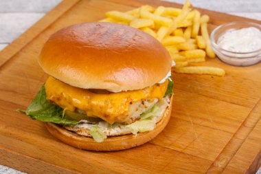 Balık, peynir ve salata soslu ev yapımı burger patates ve beyaz sos.