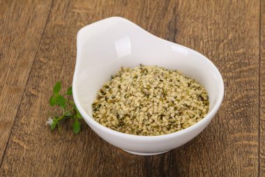 Ahşap arka planda kabuktaki kenevir tohumları.