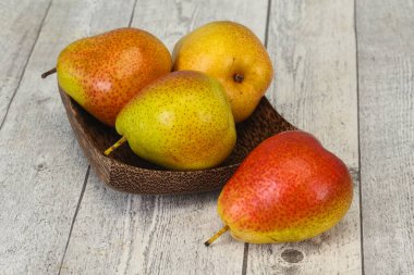 Tahta sepetteki olgun armut yığını.