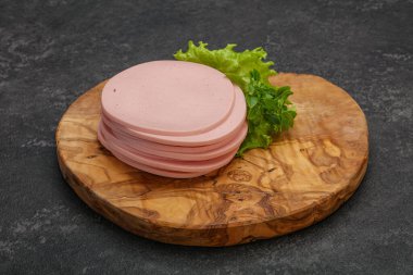 Dilimlenmiş domuz doğal sosisi güvertede fesleğen servis edilir.