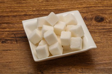 Rafine edilmiş beyaz granüllü şeker yavruları kasede.