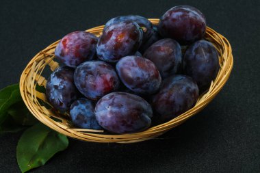 Olgun erik yığını sepetin içinde yapraklarla