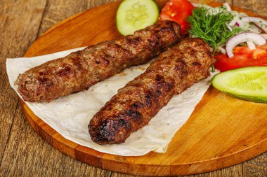 Biftek dilimlenmiş et shashlik sebze servis ediyordu.