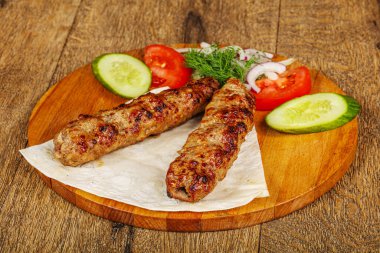 Biftek dilimlenmiş et shashlik sebze servis ediyordu.