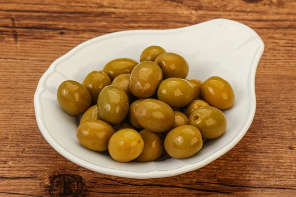 Green pickled olives heap in the bowl