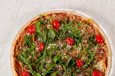 Hamon ve roka ile pizza.