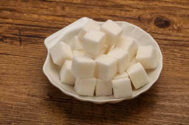 Rafine edilmiş beyaz granüllü şeker yavruları kasede.