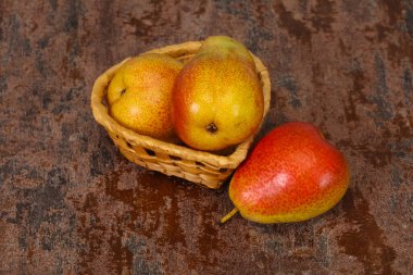 Tahta sepetteki olgun armut yığını.